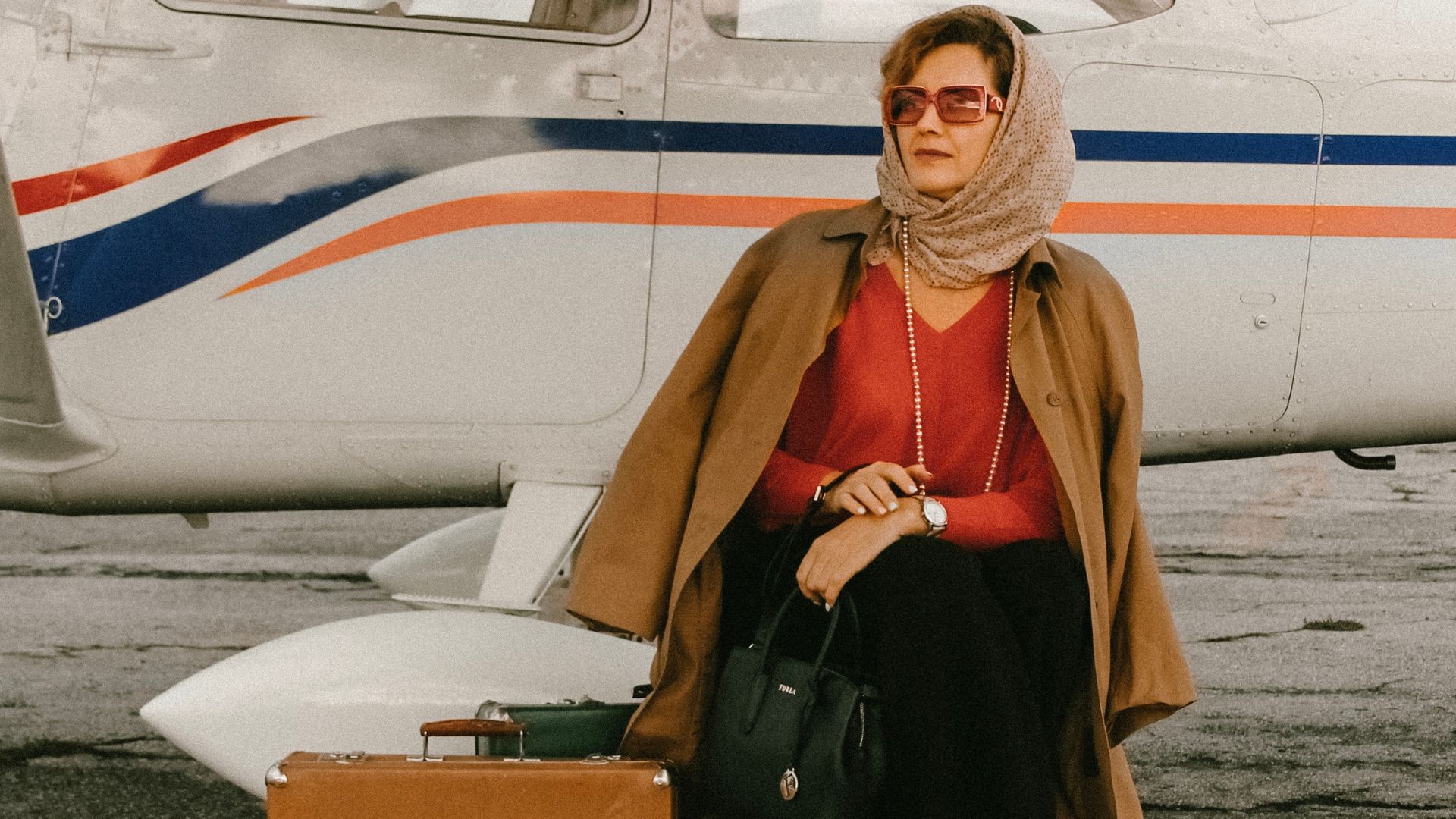 Naine istub kohvril lennuki eest päikesprillid peas