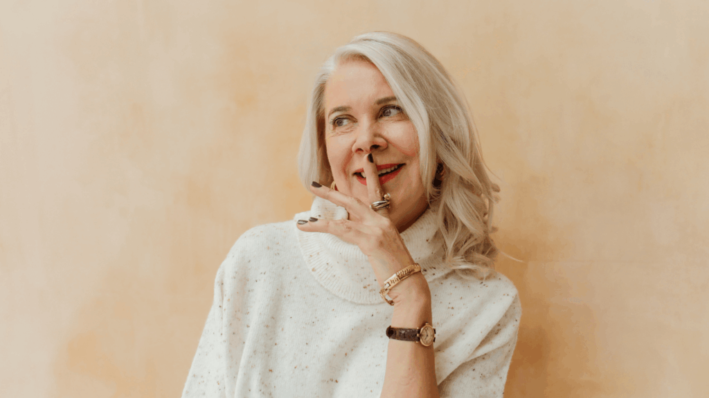 Kollageen, keskealine naine, sõrm huultel ja naeratab